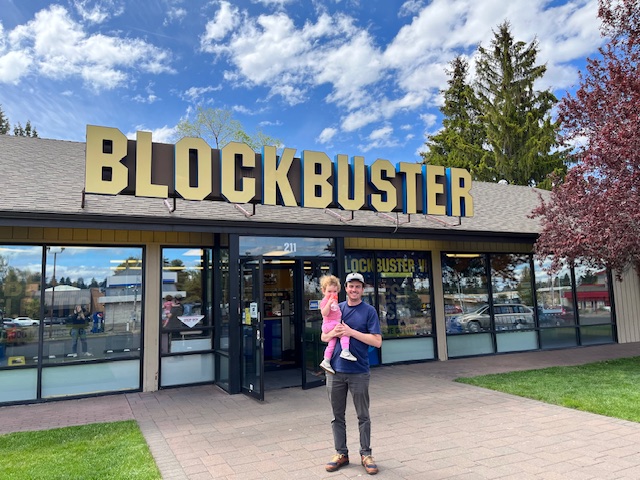 Standing in front of a Blockbuster store